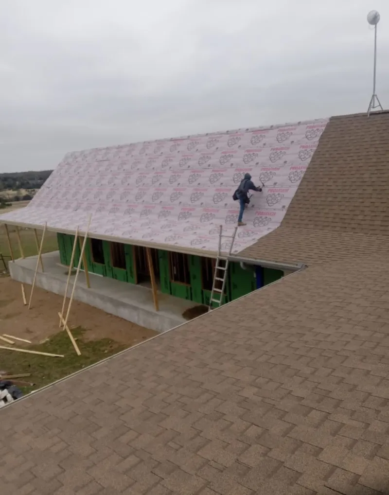 Worker preparing underlayment for a metal roof installation in Bethesda